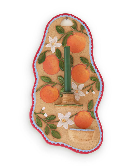 Decorative candle holder with oranges and flowers on a white background
