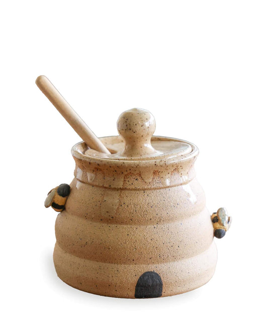Ceramic pot with wooden handle and lid on a white background